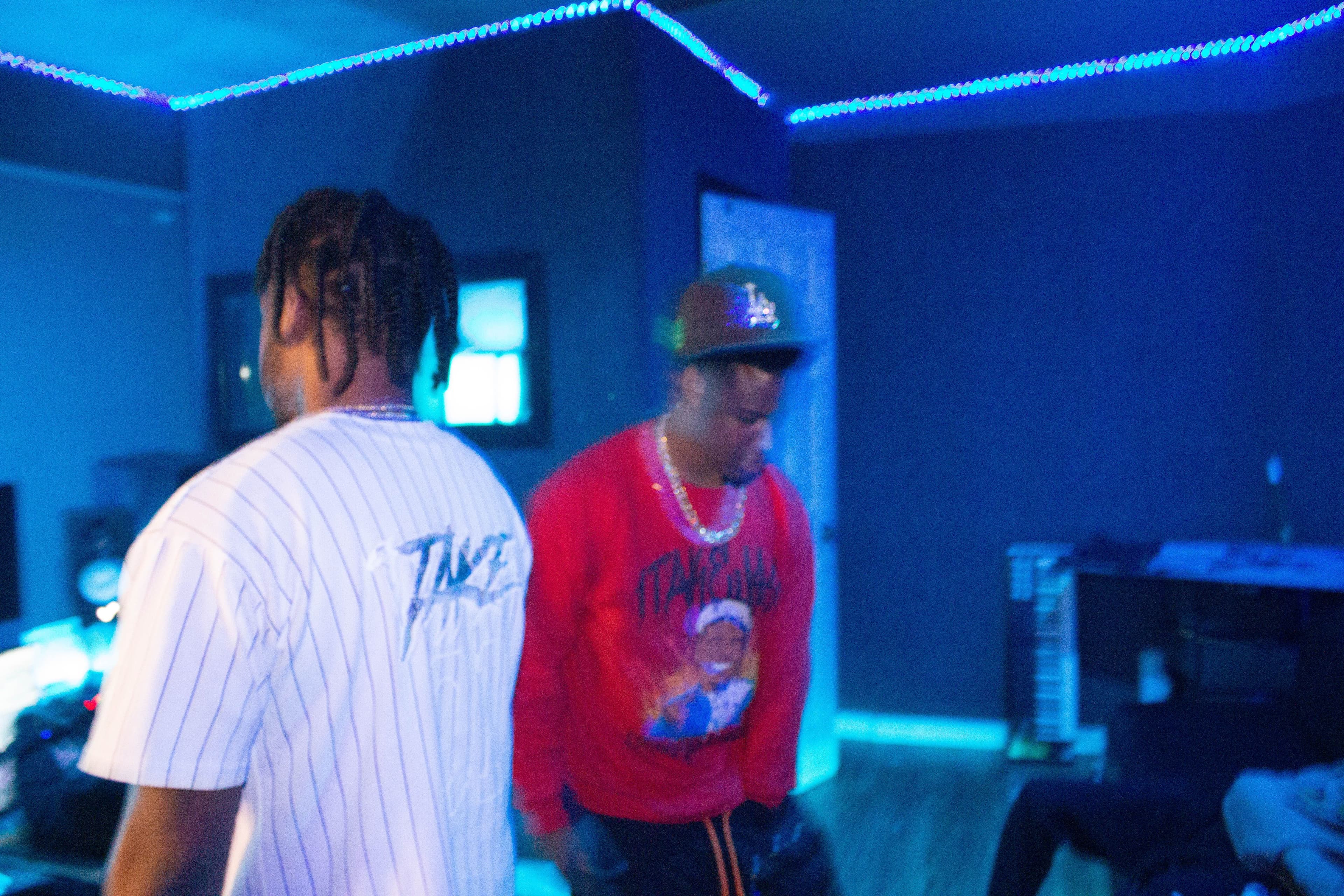 Two people in a blue-lit studio