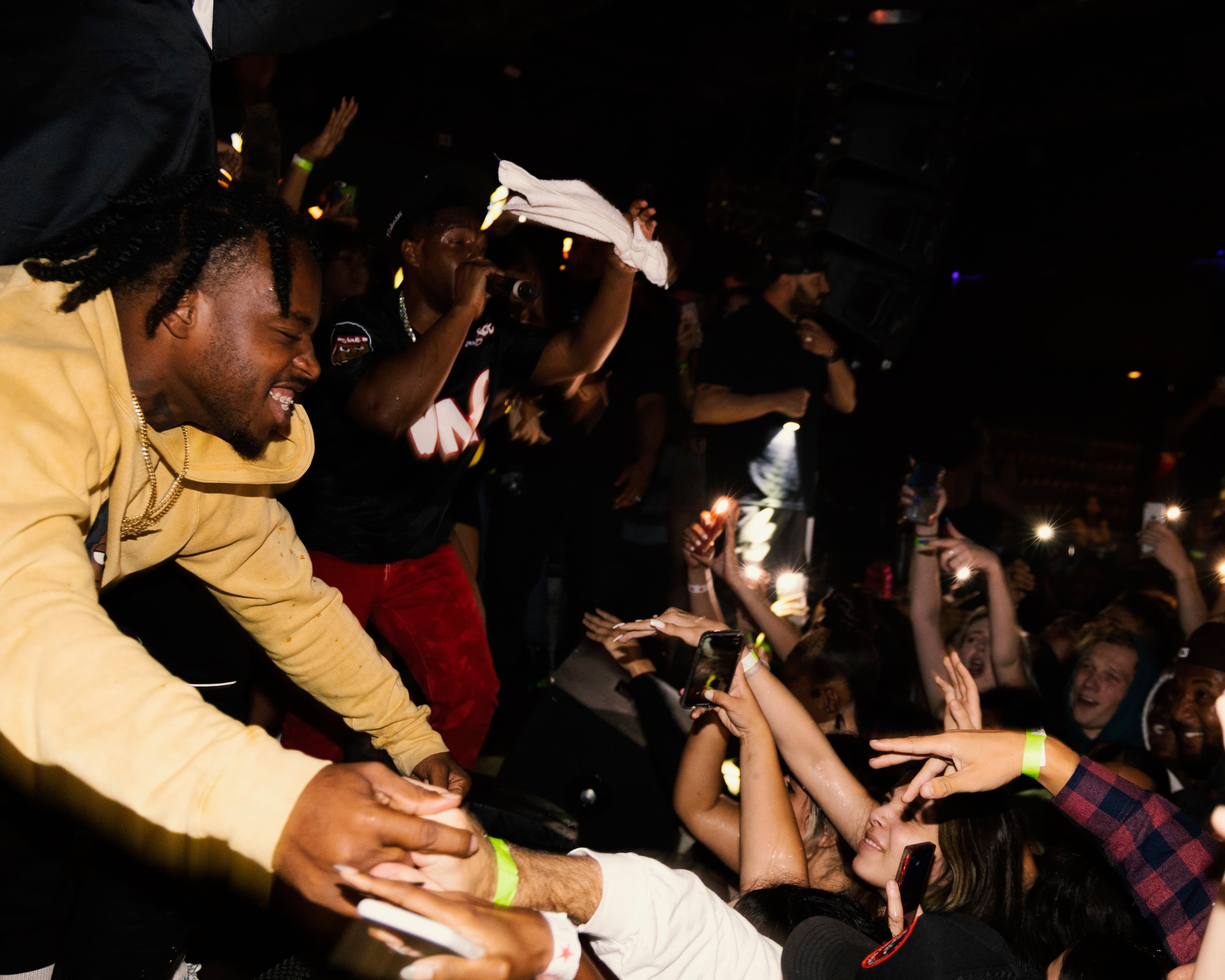 Fans reaching toward 1TakeQuan at the front of the crowd