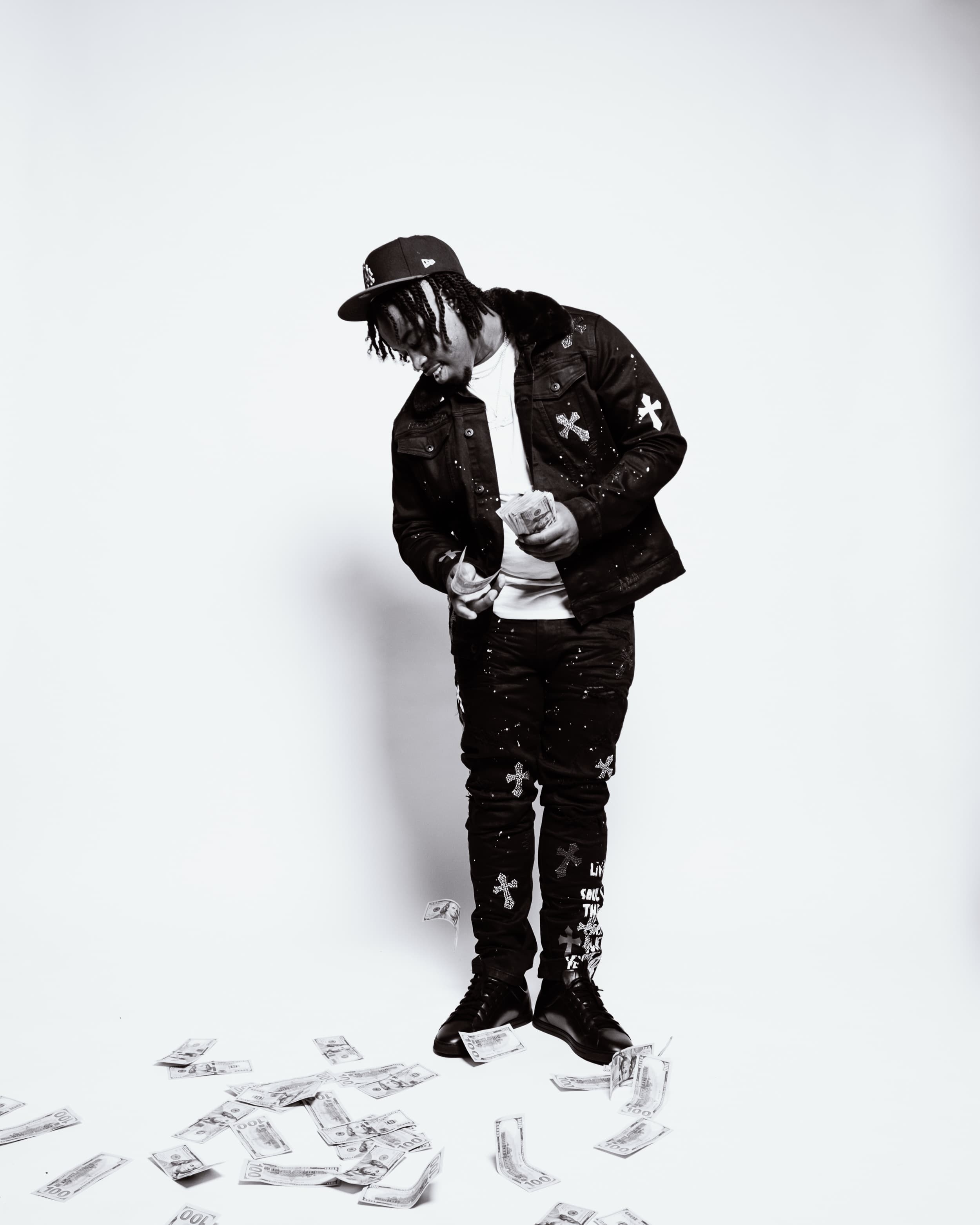 1TakeQuan in a white studio with cash on the floor