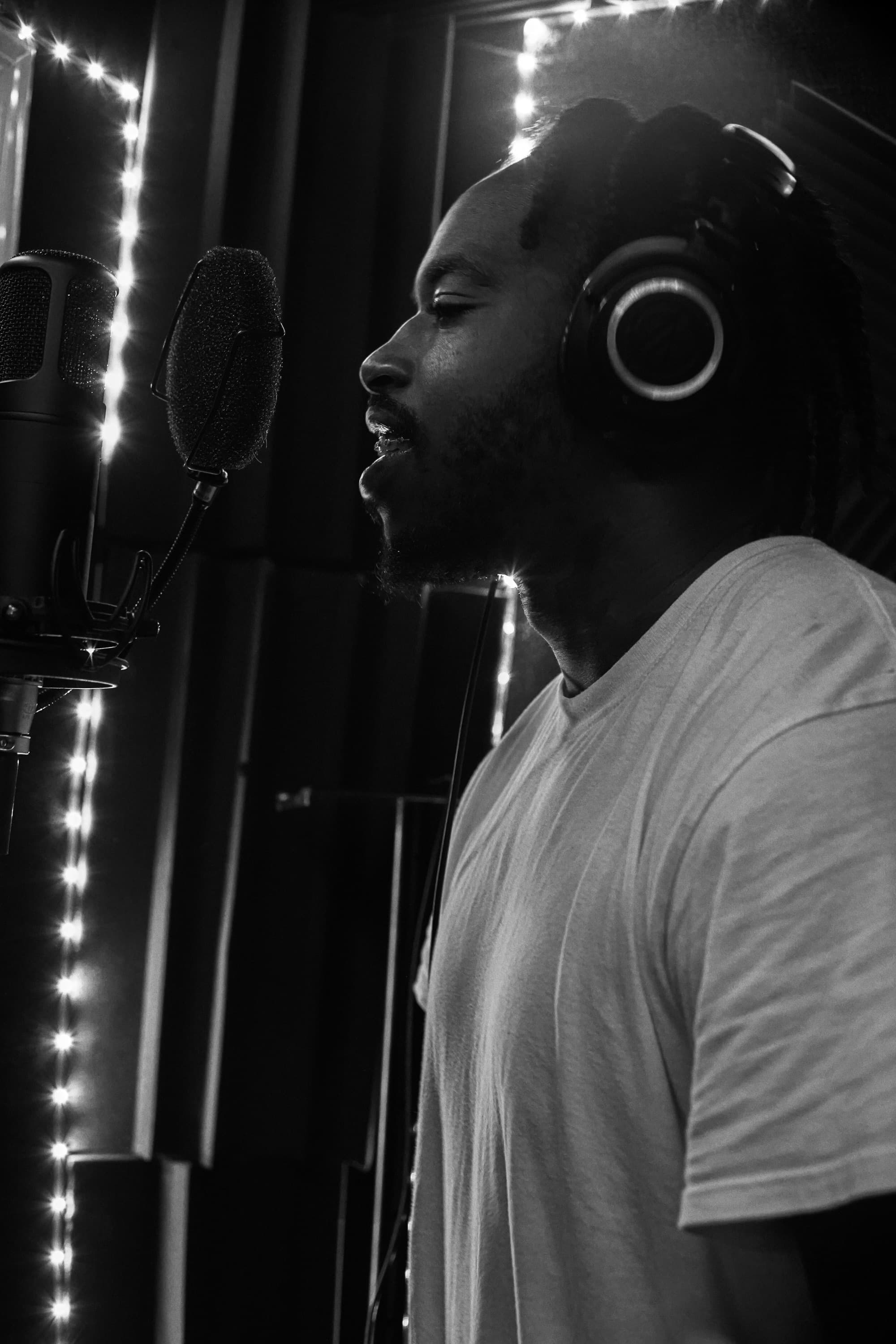 1TakeQuan in profile, singing into a studio microphone, black and white