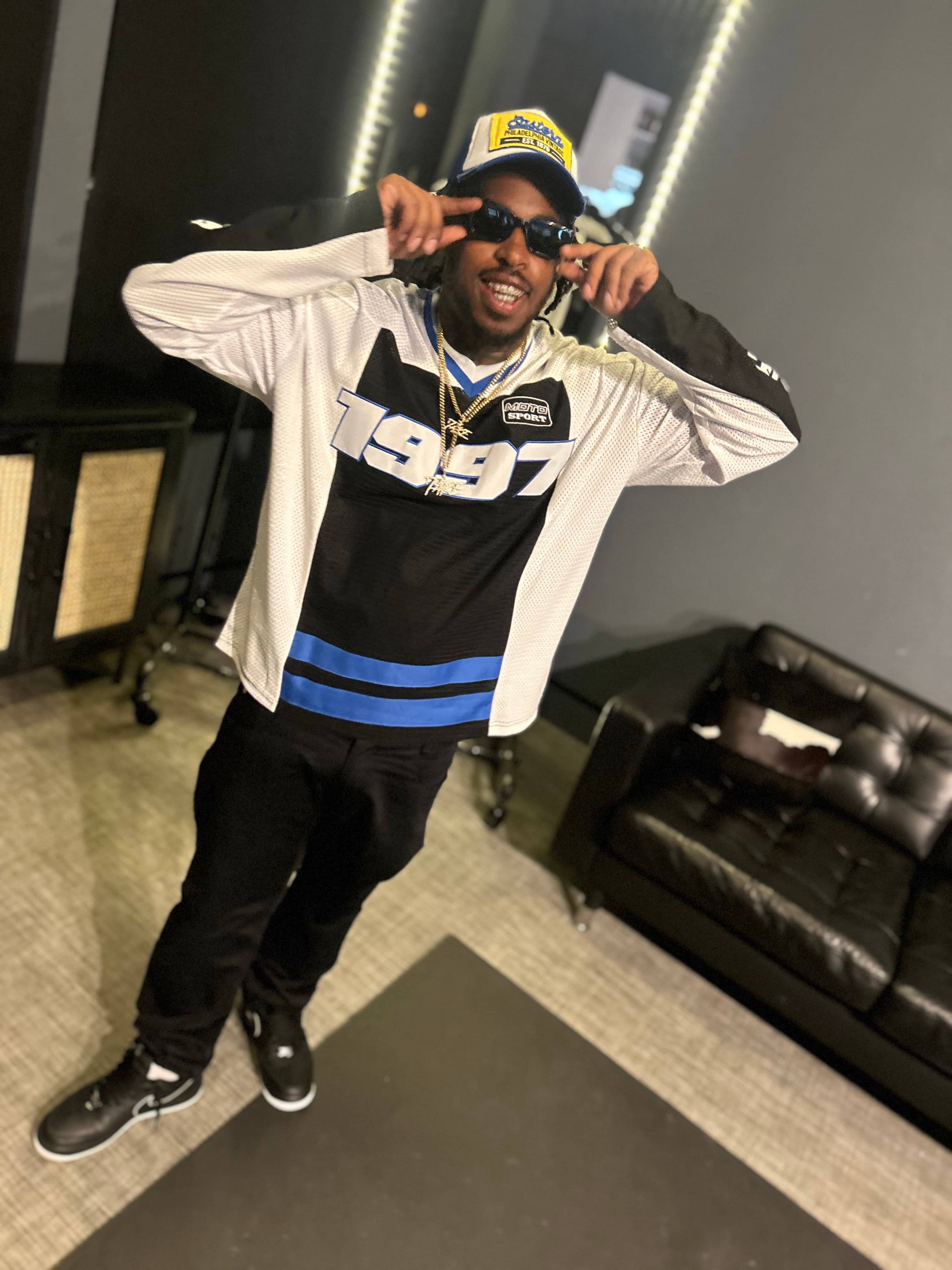 1TakeQuan posing in a striped jersey and sunglasses