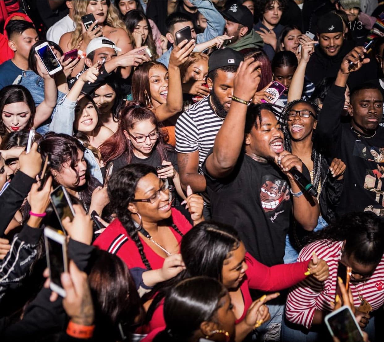A dense crowd of fans holding up phones
