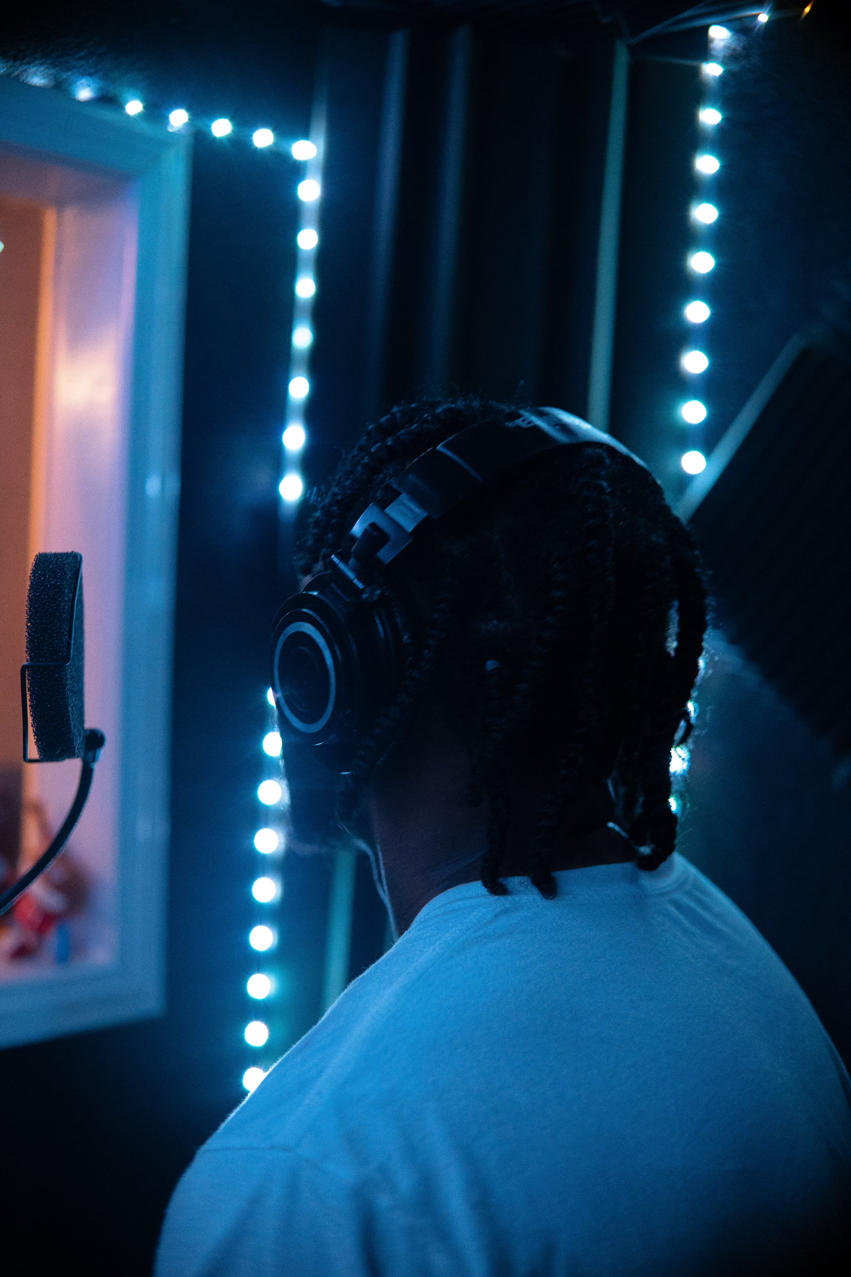 1TakeQuan in the studio booth, seen from behind in blue light